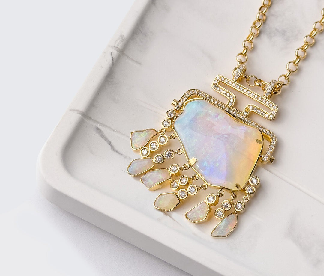 a gold opal pendant necklace with diamond accents against a neutral background