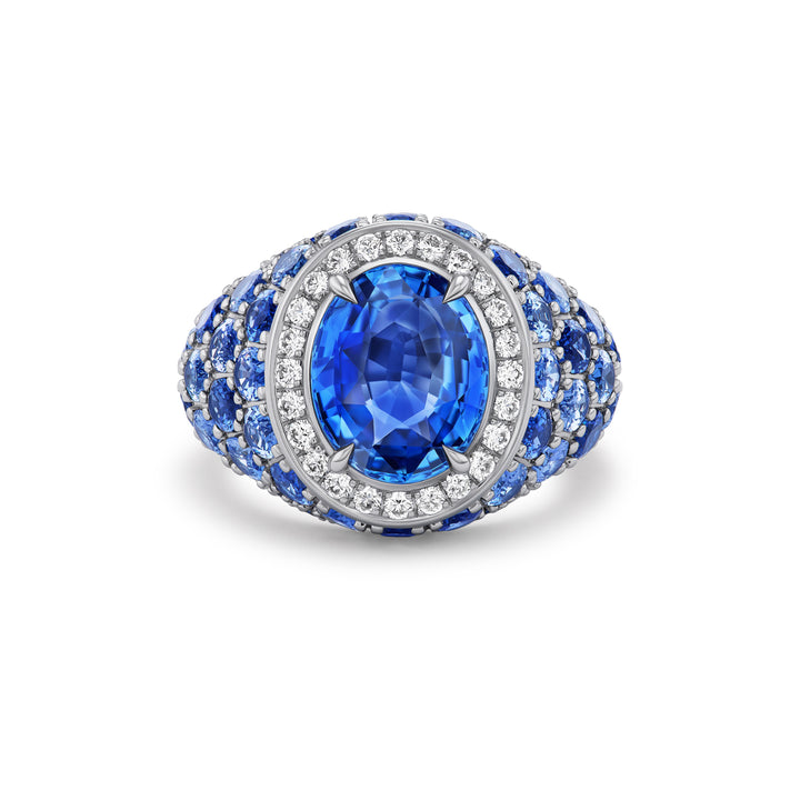 18K White Gold Celebration Ring with 5.63 ct Oval Blue Sapphire Center, Diamond Halo and Blue Sapphires and Diamonds on the Side
